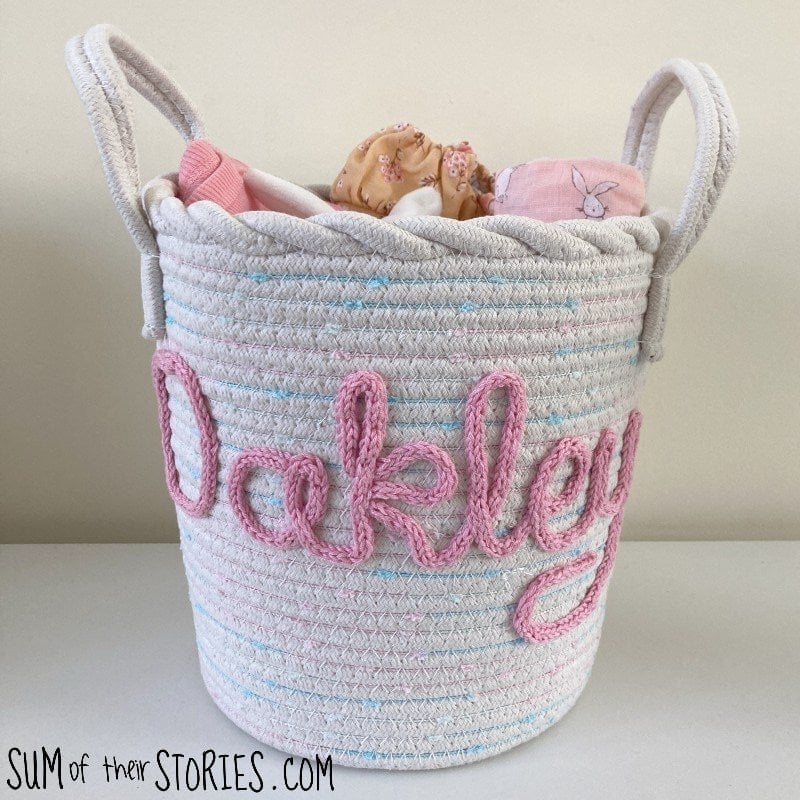Learn how to personalize a plain rope basket with a name using a simple crochet i-cord and hand stitching. This step-by-step tutorial from Sum of Their Stories shows you how to turn an everyday basket into a thoughtful, handmade gift—perfect for nurseries, storage, or special occasions.